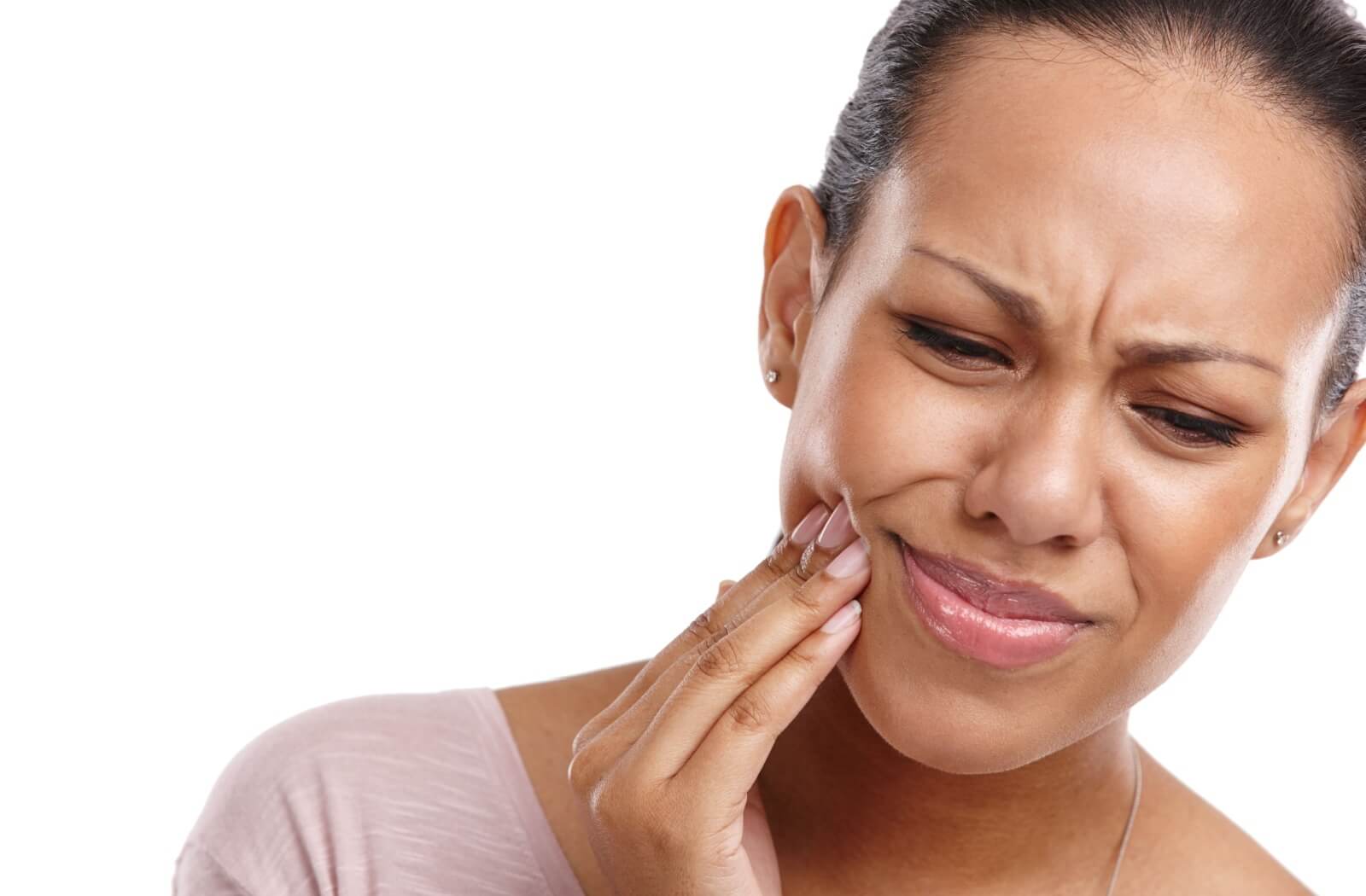 A patient gently rubs their cheeks with their fingers to soothe the aches caused by wisdom teeth.