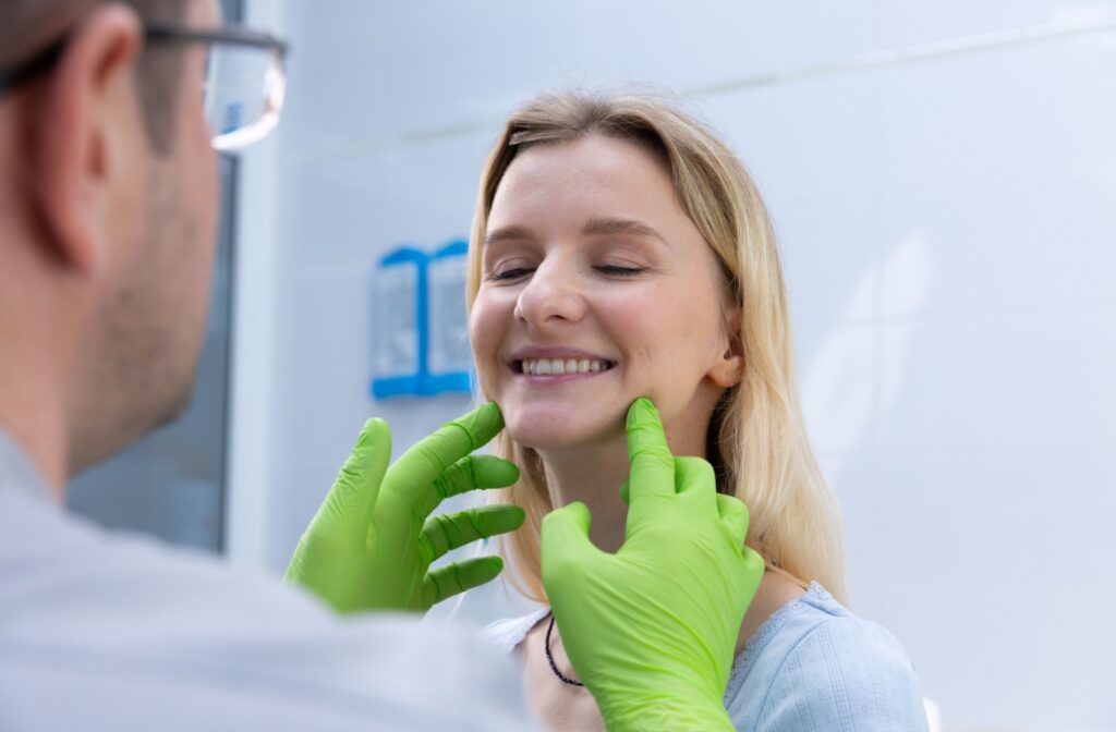 A dentist performing a comprehensive evaluation on a patient to discover what is causing their TMJ pain